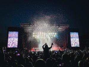 a group of people on a stage with a crowd watching
